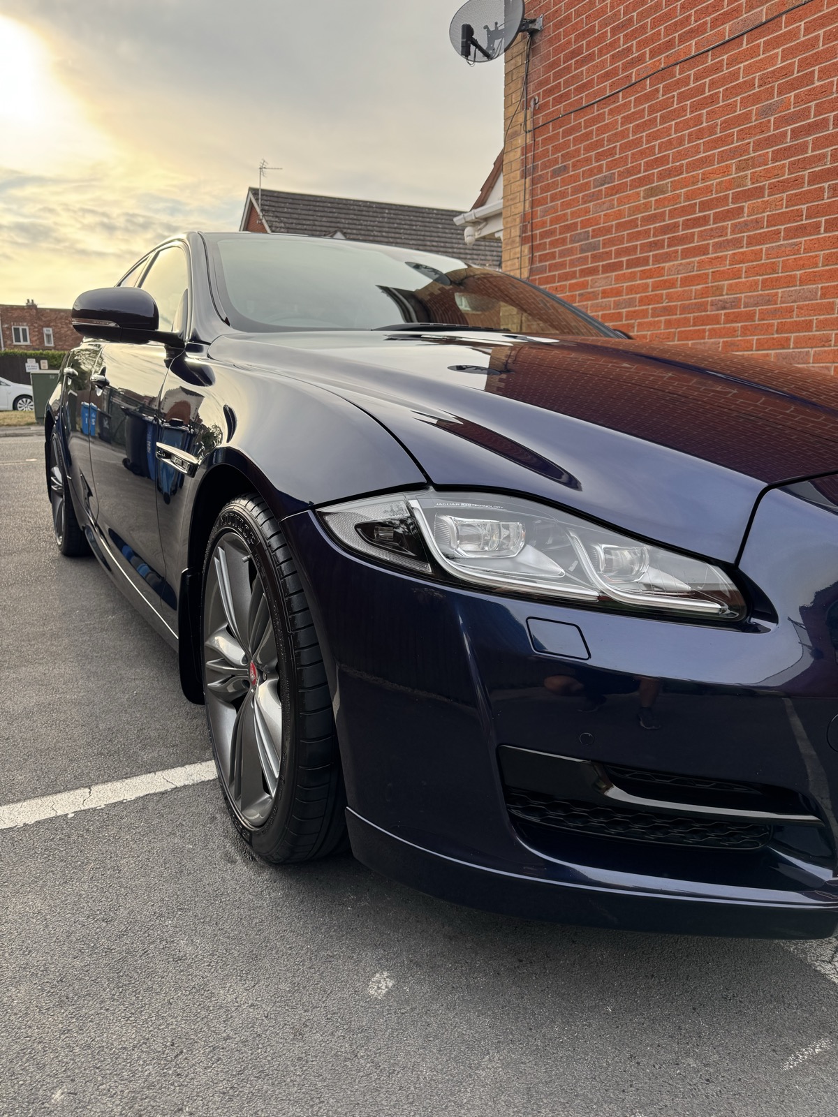 Close-up of a Jaguar XJ's front wheel and headlight after paint correction in Widnes